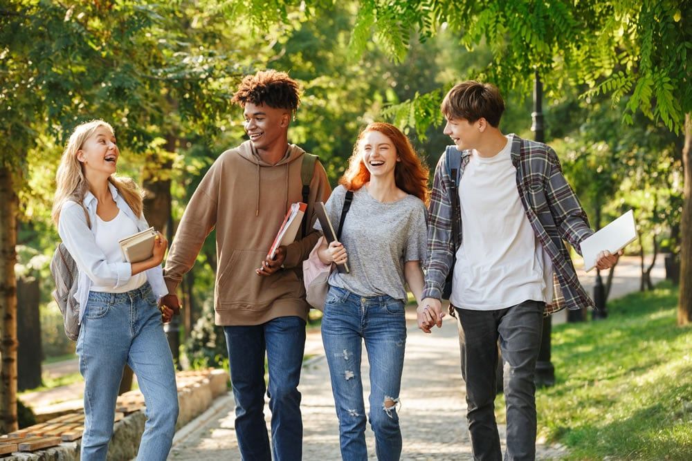 A diverse group of students walking together on a green campus