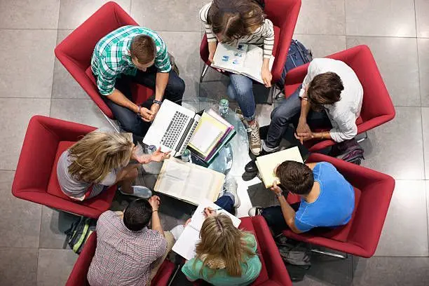 A collaborative research group reviewing notes and evidence around a shared table